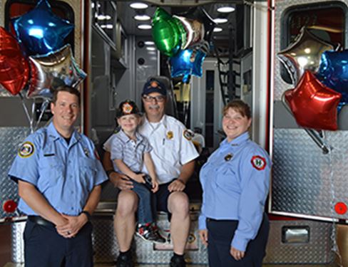 Paramedics with citizens at back of ambulance